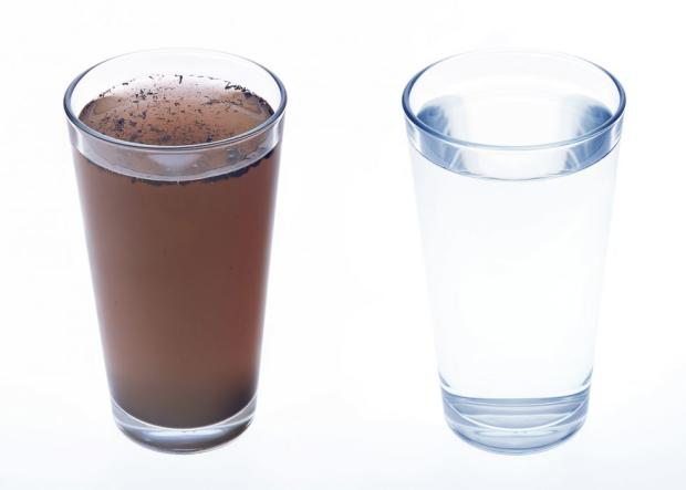 A picture of two glasses, on the left the glass is filled with dirtly looking water that has manganese in it, the one on the right is clear, clean water.